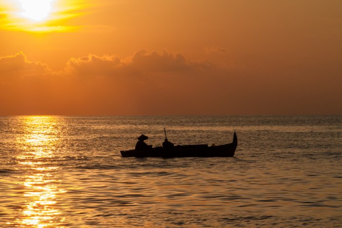 Bateau sur l'eau au coucher du soleil