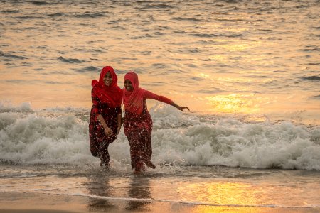 Baignade au coucher du soleil sur la plage d'Alleppey, Inde