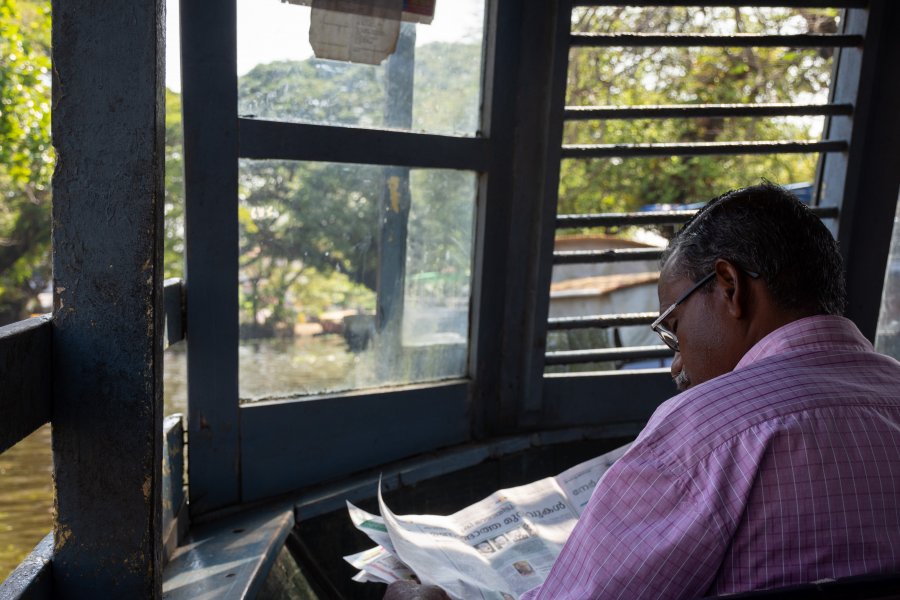 Lecture de journal sur le ferry public d'Alleppey, Kerala