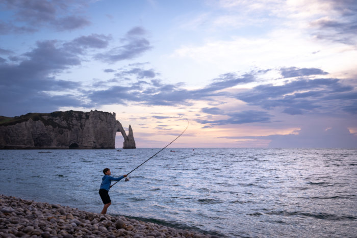 Pêcheur sur la plage d'Etretat au coucher du soleil