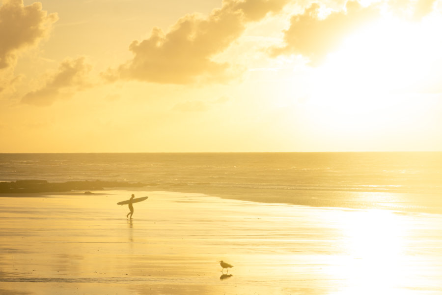 Surfeur sur la plage de Dieppe au coucher du soleil