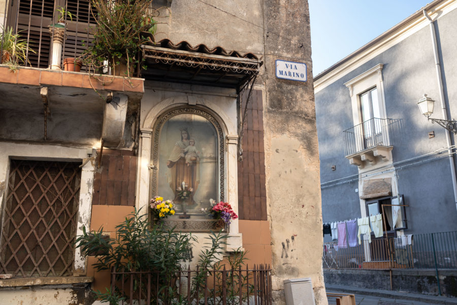 Autel religieux et linge dans une rue de Catane